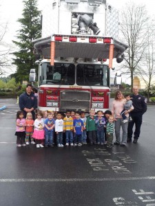 Kids in front of fire truck with Firemen