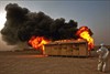 CAMP AL TAQADDUM, Iraq (September 3, 2008) - U.S. Marine Corps Sgt. Jason W. Fudge, combat videographer, 1st Marine Logistics Group, records the burning of a Southwest Asia hut at Camp Al Taqaddum, Iraq, Aug. 30, 2008. The safety video highlighted the affects of a fire on a hut. Photo by Lance Cpl. Gabriela Garcia, U.S. Marine Corps.