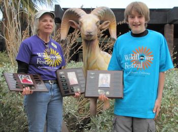 Two volunteers hold awards for their volunteer work.