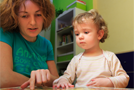 Woman points out a picture to a young girl