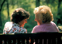 Two women talking while seated on a park bench
