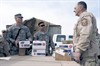 RASHAAD, Iraq (March 13, 2007) - U.S. Air Force Senior Master Sgt. Wayne Stierlen, right, gives school supplies and children's clothes to Army Sgt. 1st Class William Story, left, and Staff Sgt. Jeffery Joco on Kirkuk Regional Air Base, Iraq, March 8, 2007. The school supplies and clothes will be given to the children of Rashaad, Iraq. Photo by Senior Airman Bradley A. Lail, U.S. Air Force.