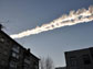 Sky showing a meteor as it streaked by buildings in Russia.