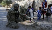 U.S. Army Spc. Kyle Johnson, a security force team member assigned to Provincial Reconstruction Team Farah, hands a young girl a piece of candy across from the site of a key leader engagement in Farah City, Afghanistan, Jan. 22, 2013. U.S. Navy photo by Lt. j.g. Matthew Stroup