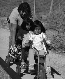 mujer con niñas en triciclos