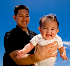 Man plays with laughing baby