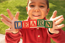 Boy holds up blocks which spell 'Learn'