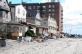 Local residents stack piles of debris outside of their home