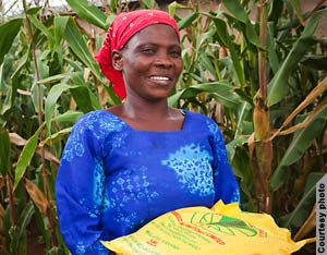 Woman in maize field holding bag of seed (Courtesy of Gates Foundation)