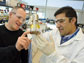 Photo of JBEI Director Jay Keasling with Rajit Sapar in lab with a beaker of cellulose sludge.