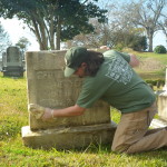 Instructor Jason Church cleans a marble headstone