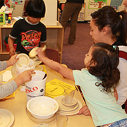 A teacher and young students around a table