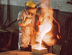 An NETL technician pours a cast stainless steel P-900 hatch for a military fighting vehicle using the lost foam process.