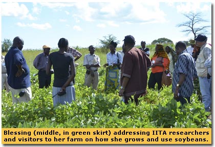 Blessing explaining to a group of IITA researchers