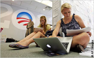 两位女青年坐在地上用电脑输入资料 (AP Images)