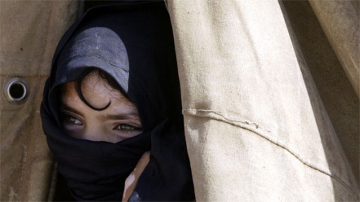 An Iraqi girl peers from her tent in a camp near Baghdad, Iraq September 11, 2007. [AP photo]