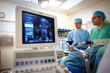 Photo shows Bradford Wood, M.D., and Peter A. Pinto, M.D., performing a prostate biopsy.