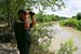 A CBP Border Patrol agent scans the area into Mexico with binoculars looking for illegal immigrants potentially staging to enter the U.S.