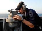 Coast Guard Member looking through a sextant