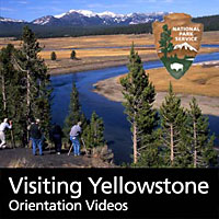 Visitors watching a Hayden Valley scene with the Yellowstone River and distant mountains.