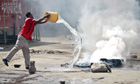A man throws water over a burning tyre set alight in a street by Muslim youths in Mombasa, Kenya