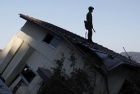 A member of the Japan Self Defense Force stands on a house at an area that was damaged by the March 11 earthquake and tsunami, in Yamada, Iwate prefecture April 5, 2011. REUTERS/Toru Hanai 