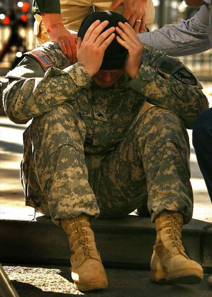 A file photo shows an Army veteran who was diagnosed with PTSD and traumatic brain injury being comforted by his father at a Veterans Day parade in 2008.