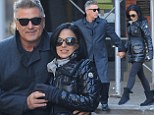 Alec Baldwin looks cheerful as he snuggles up to Hilaria on romantic stroll... after appearing annoyed while out in the snow