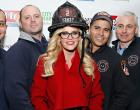 
NEW YORK, NY - DECEMBER 12:  TV personality Jenny McCarthy (C) poses with firefighters at the The 2013 Daily News Readers Care To Feed the Hungry Canned Food Drive Hosted By City Harvest at Battalion 8 on December 12, 2013 in New York City.  (Photo by Cindy Ord/Getty Images)