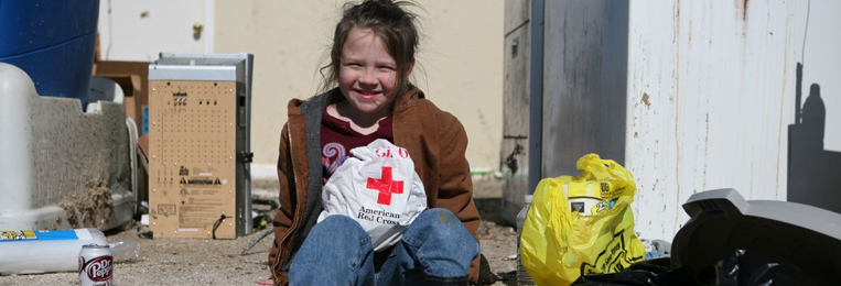 Little girl after a disaster with a Red Cross bag