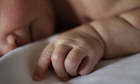 Newborn baby asleep in hospital bed