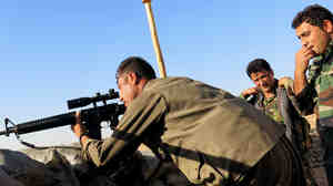 Peshmerga look out from a front-line outpost — a few sandbags, soldiers, and grenades perched on the brow of a hill — to the eastern Iraqi town of Jalula. The Kurdish fighters are grappling with how to combat changing ISIS tactics.