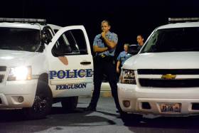 A police officer observes the crowd gathered in protest the police shooting of teenager Mike Brown, Ferguson, Missouri, Sept. 29, 2014.