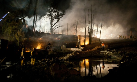 A crater filled with water marks the site of an explosion that caused a fire the massive fire burning in a residential neighborhood 9 September 2010 in a San Bruno, California.