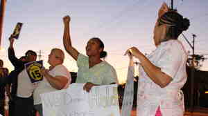 Home health care workers Jasmine Almodovar (far right) and Artheta Peters (center) take part in a Cleveland rally for higher pay on Sept. 4.