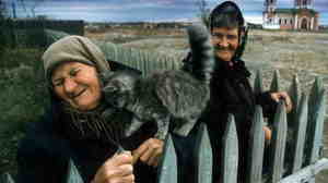 A kitten loves on an old woman in the Cossack village of Velikopetrovskaya near Cheliyabinsk.