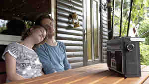 Germany, Hamburg, Man and woman listening to radio in cottage at allotment garden