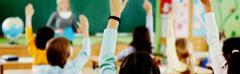 Classroom with children raising their hands