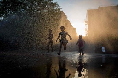 Children enjoying a sprinkler at a playground in Brooklyn in July. Children below age 6 may be more vulnerable to playground injuries because of parents who are focused on their smartphones, according to a study.