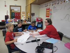 Justin, Austin and Davon get personalized instruction from literacy specialist Olivia Weisman. 