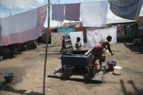 People draw water in the West Point neighborhood, where many people have died from Ebola, in Monrovia, Liberia on Oct. 17, 2014.