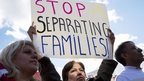 Light is reflected on Sara Ramirez, of Gaithersberg, Maryland  as she rallies for comprehensive immigration reform outside the White House in Washington, 7 November 2014