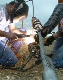 Man welding a cable.