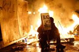 A demonstrator sits in front of a street fire in Oakland. (Stephen Lam—Reuters)

See TIME's best pictures of the week http://ti.me/1uSmq1K