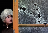 A child stands next to a bullet shattered window during the 1989 anti-communist revolution in Timisoara, December 23, 1989.