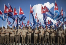 Members of the Cuban Revolutionary Army hold Cuban national flags during a march "For the Five and Against the Terrorism" in Havana September 30, 2014. REUTERS/Alexandre Meneghini