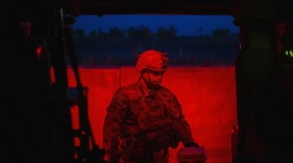 A U.S. soldier from Grim Company of the 3rd Cavalry Regiment carries his food into an MRAP vehicle for an early morning mission at Forward Operating Base Fenty in the Nangarhar province of Afghanistan December 19, 2014. REUTERS/Lucas Jackson 