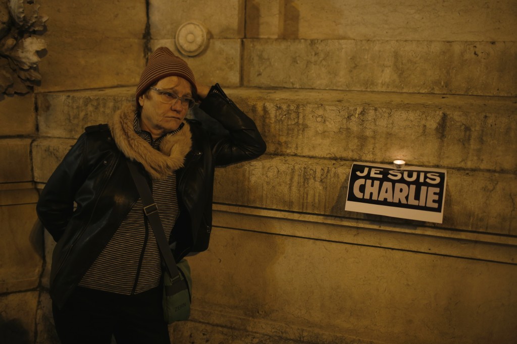 A woman participates in a vigil to pay tribute to the victims of a shooting, by gunmen at the offices of weekly newspaper Charlie Hebdo, in downtown Lisbon