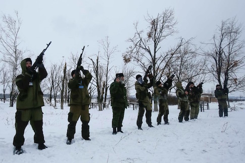 Pro-Russian separatists fire in the air during a laying of the capsule ceremony for the chapel, to be built in memory of rebels and civilians who were killed in eastern Ukraine, at a destroyed war memorial at Savur-Mohyla, a hill east of the city of Donetsk, December 7, 2014