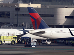 A Delta Air Lines jet, right, sits parked after making an emergency landing at Los Angeles International Airport, Tuesday, Jan. 13, 2015. The Boeing 757 experienced a mechanical problem soon after takeoff on a flight from Los Angeles to Minneapolis and had to circle off the Southern California coast for about an hour to burn fuel before landing safely back at the airport. (AP Photo/Nick Ut)